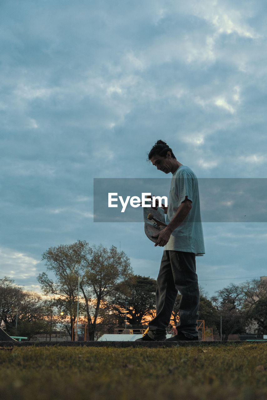 Side portrait of skateboarder during sunset