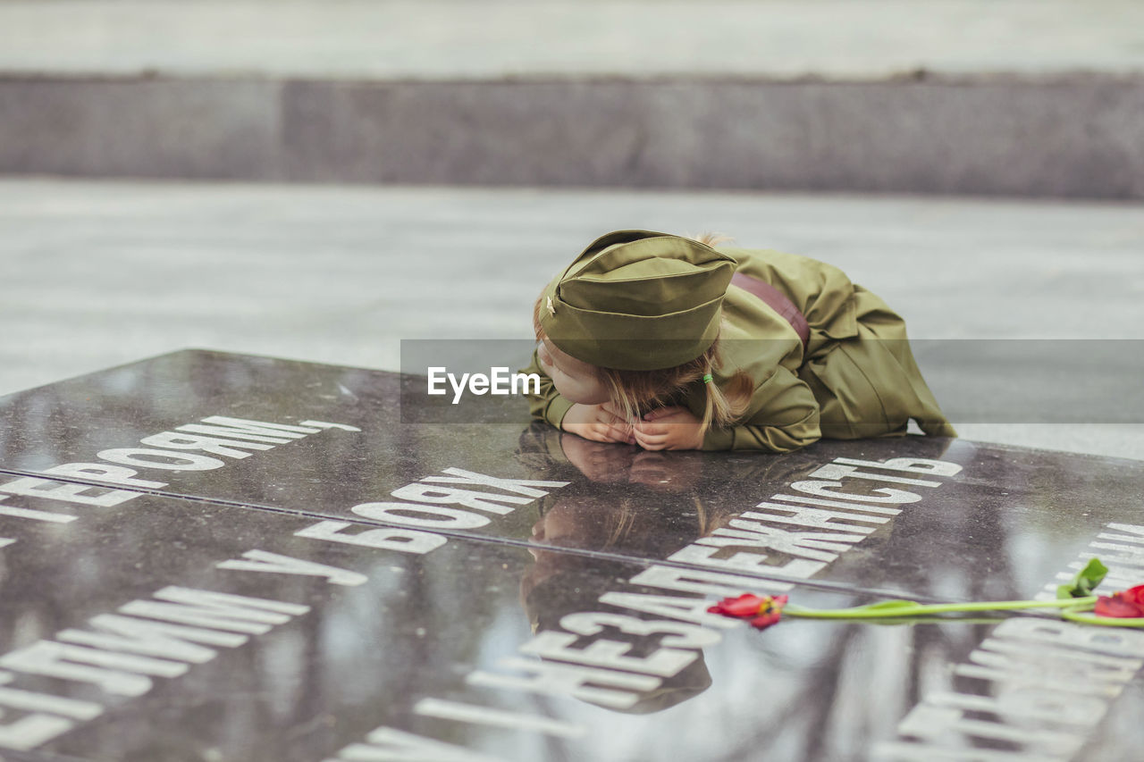Baby girl in soviet military uniform leaned against the stele to those killed in world war ii
