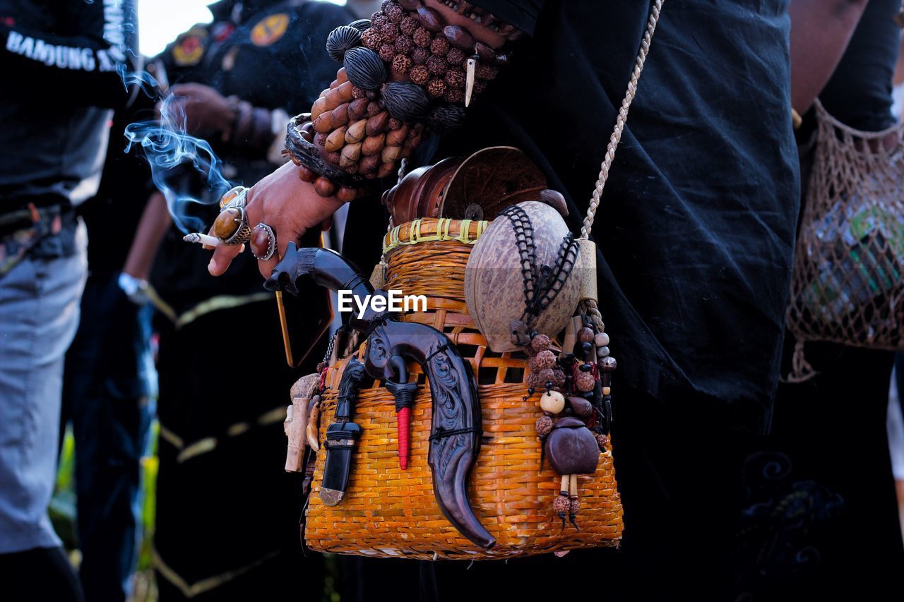 Midsection of man holding basket in market