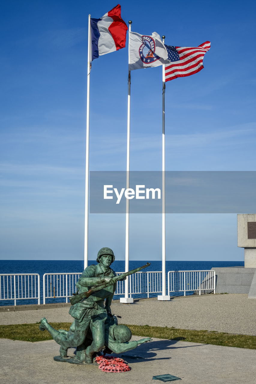 STATUE OF FLAGS AGAINST SKY