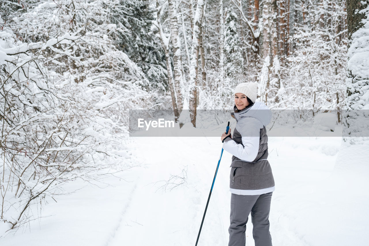 snow, cold temperature, winter, tree, footwear, nature, one person, skiing, adult, clothing, forest, white, leisure activity, nordic skiing, land, environment, plant, sports, beauty in nature, snowshoe, full length, lifestyles, holiday, mountain, cross-country skiing, standing, activity, vacation, scenics - nature, day, landscape, trip, outdoors, non-urban scene, warm clothing, tranquil scene, travel, winter sports, young adult, frozen, tranquility, ski, walking, recreation, men, ski pole, women, adventure, woodland