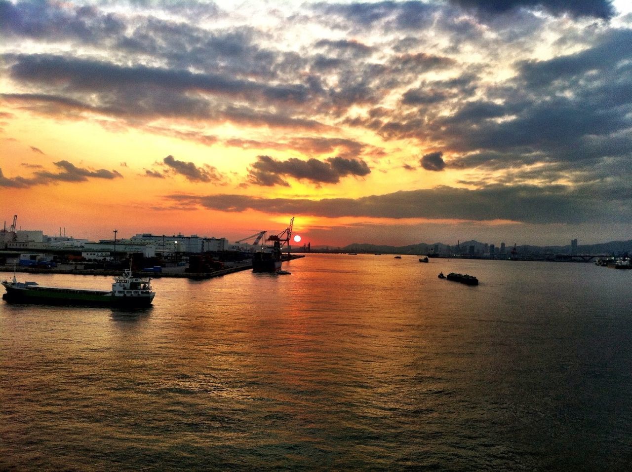 Boat in sea against cloudy sky during sunset