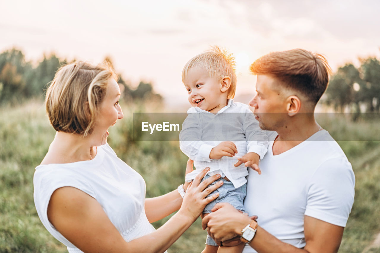 Cheerful mother and father with son on field