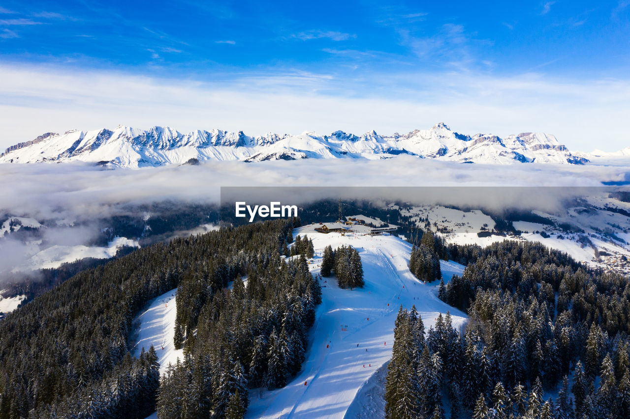 Scenic view of snow covered ski resort against sky