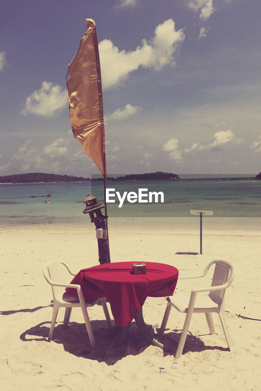 LIFEGUARD CHAIR ON BEACH AGAINST SKY