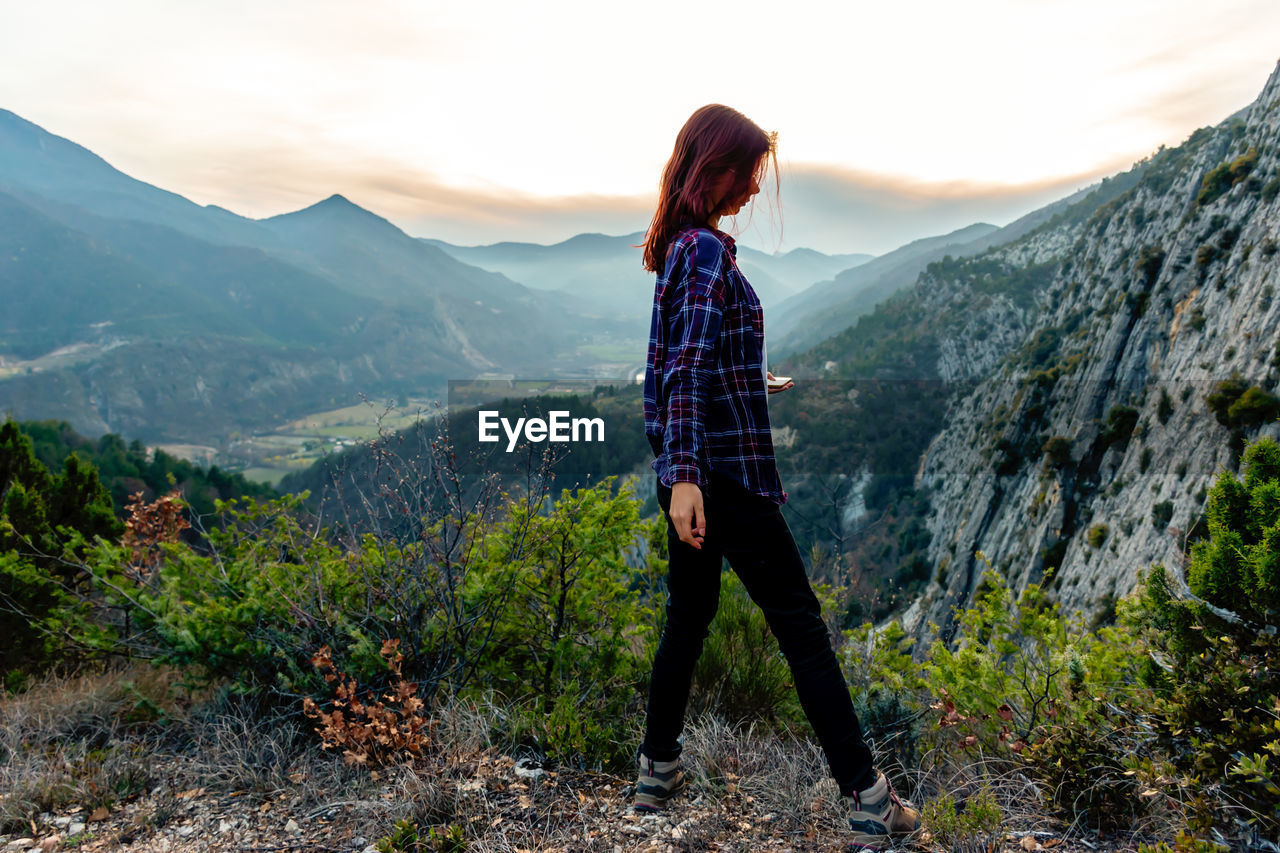 Full length of woman walking on mountain against sky