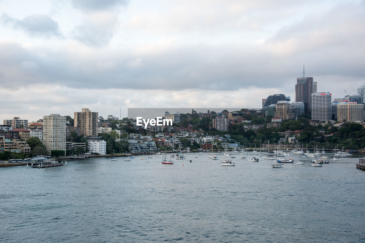 Buildings by sea against sky in city