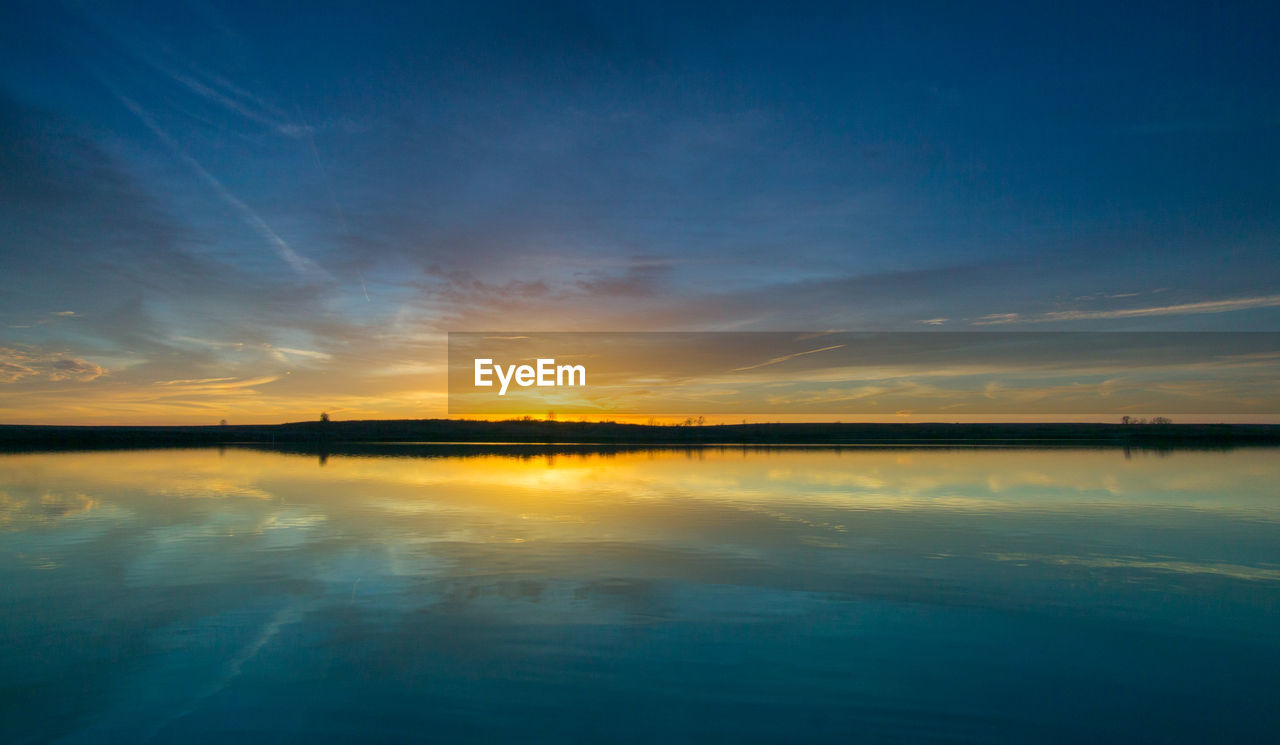 VIEW OF CALM SEA AT SUNSET