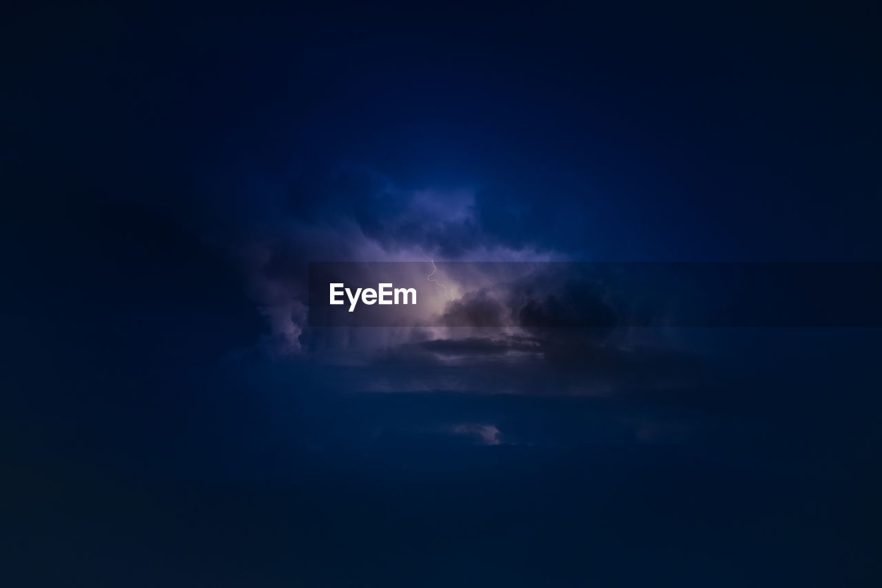 Dramatic view of heat lightning storm, thunderbolts and dramatic clouds at night time