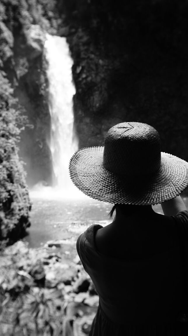 Rear view of woman looking at waterfall