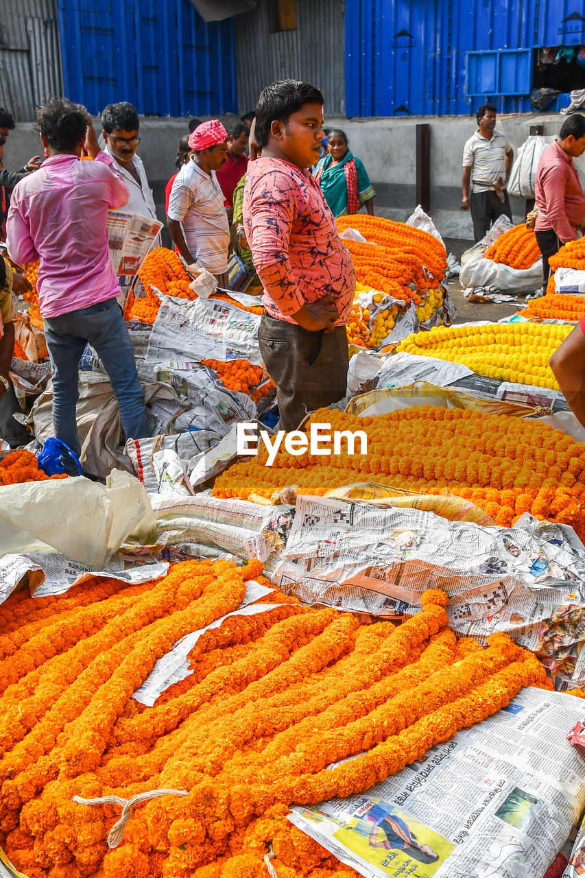 GROUP OF PEOPLE IN MARKET STALL