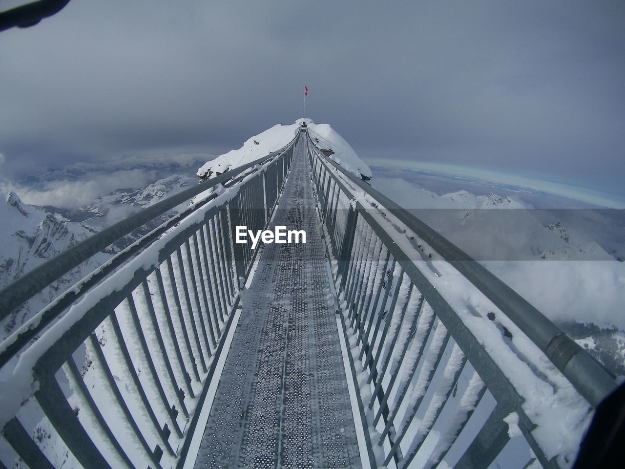 LOW ANGLE VIEW OF SUSPENSION BRIDGE IN WINTER
