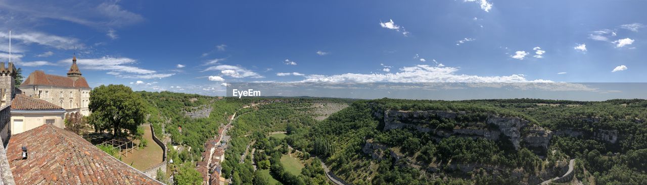 Panoramic view of trees and buildings against sky