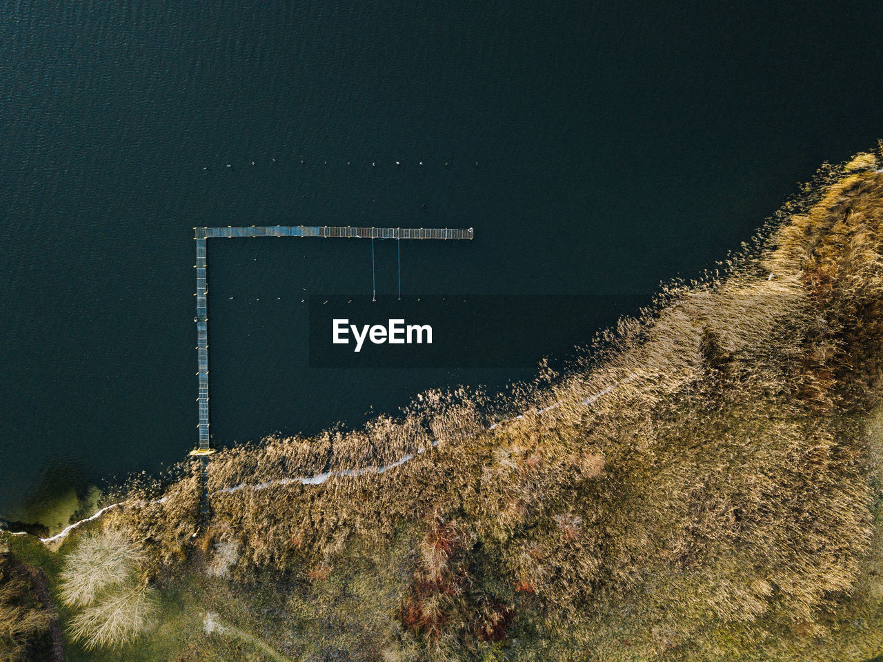 Jetty in the lake without boats from above  