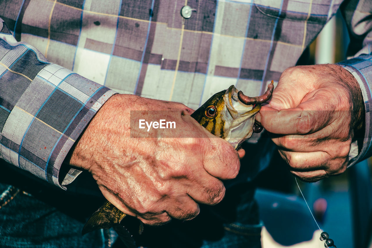 Midsection of man holding fish