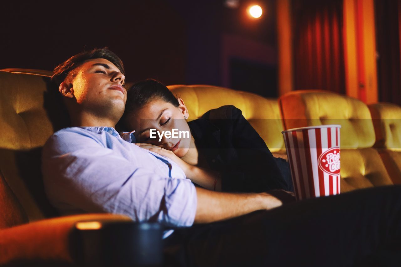 Couple relaxing with popcorn in movie theater