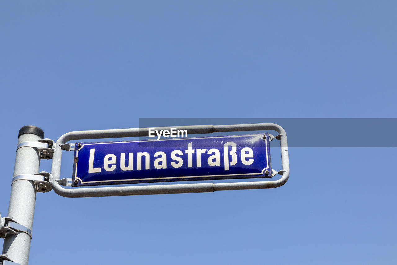 low angle view of road sign against blue sky