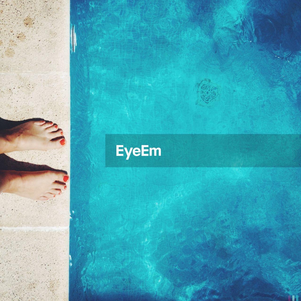 Low section of woman standing poolside