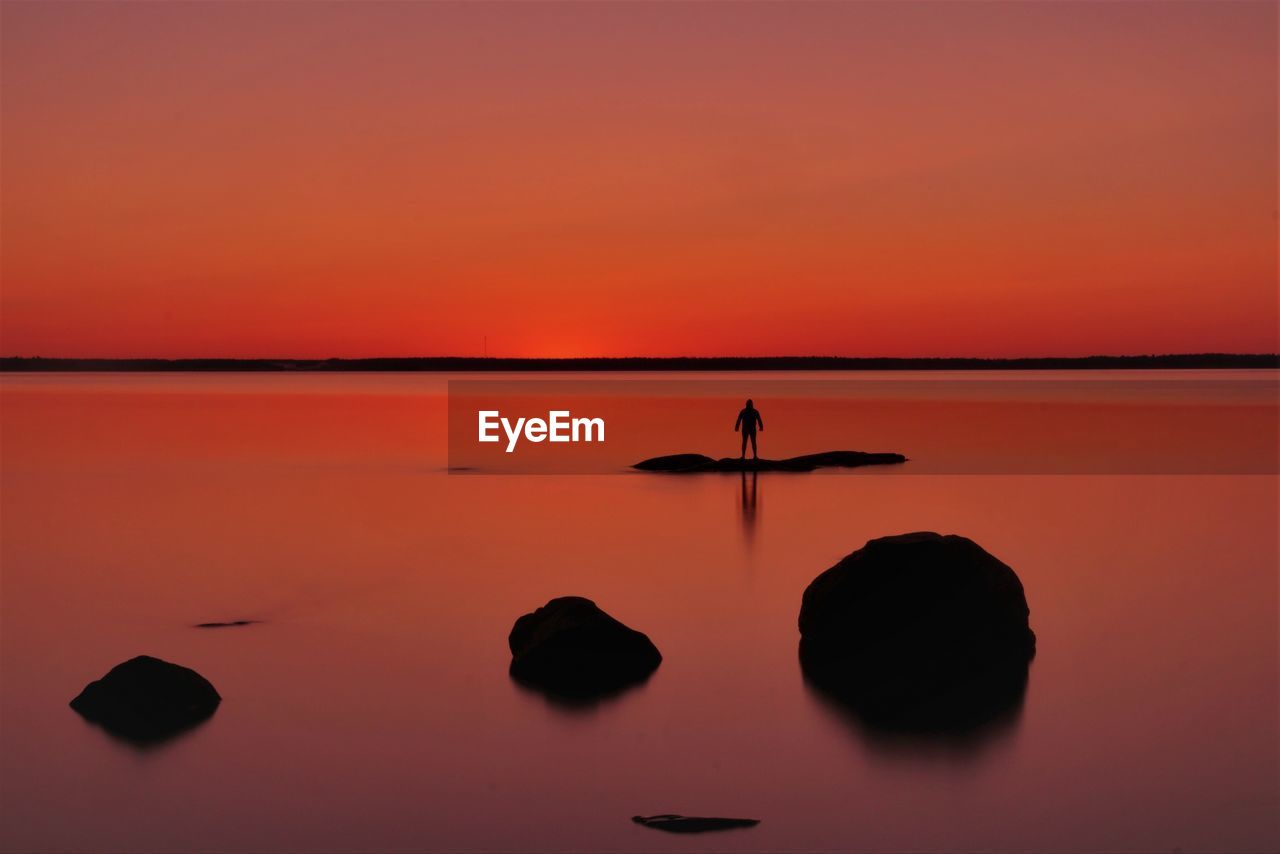 Scenic view of lake against orange sky