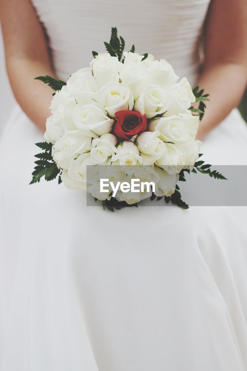 CLOSE-UP OF WOMAN HOLDING BOUQUET