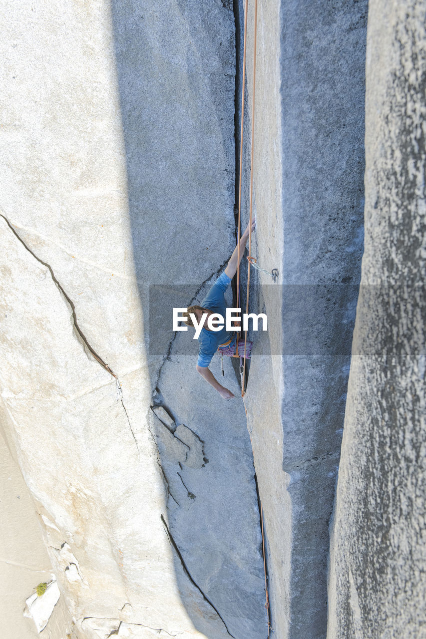 Rock climbing clipping rock while lead climbing the nose on el capitan