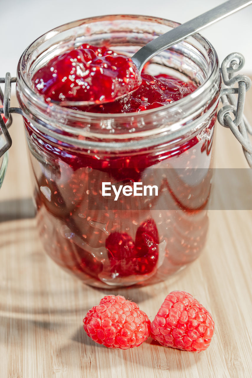 CLOSE-UP OF STRAWBERRY IN JAR ON TABLE