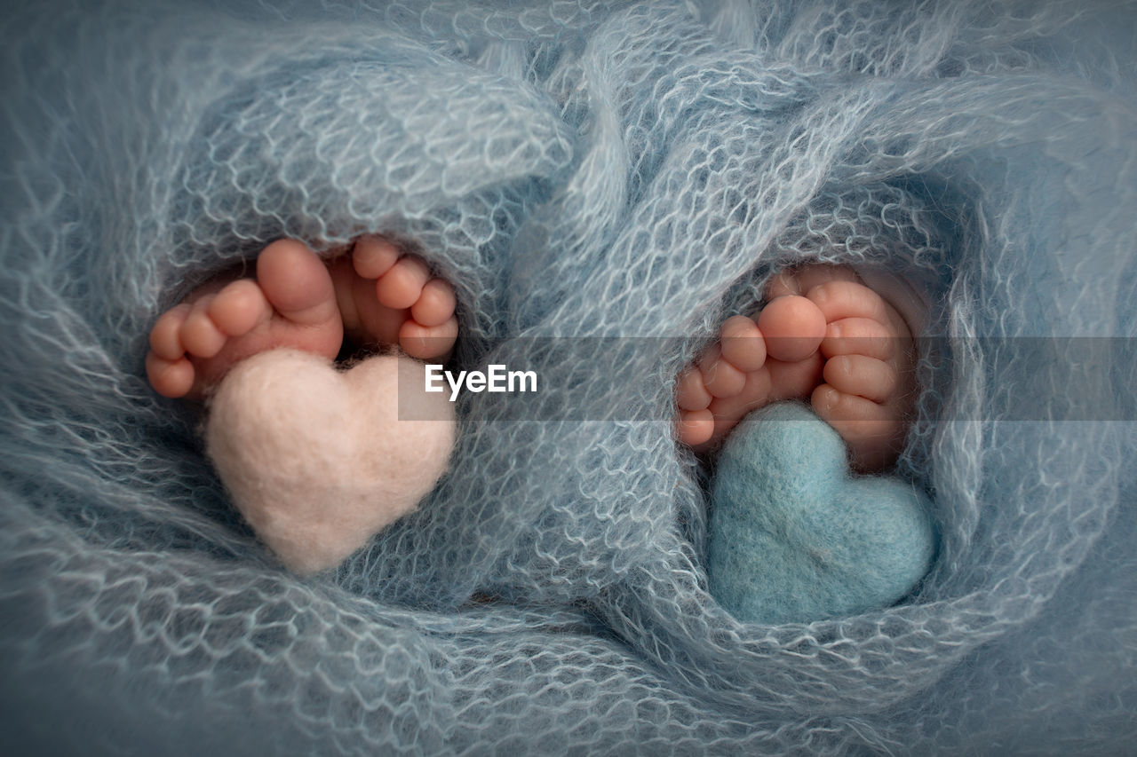 CLOSE-UP OF BABY BOY LYING ON HUMAN HAND