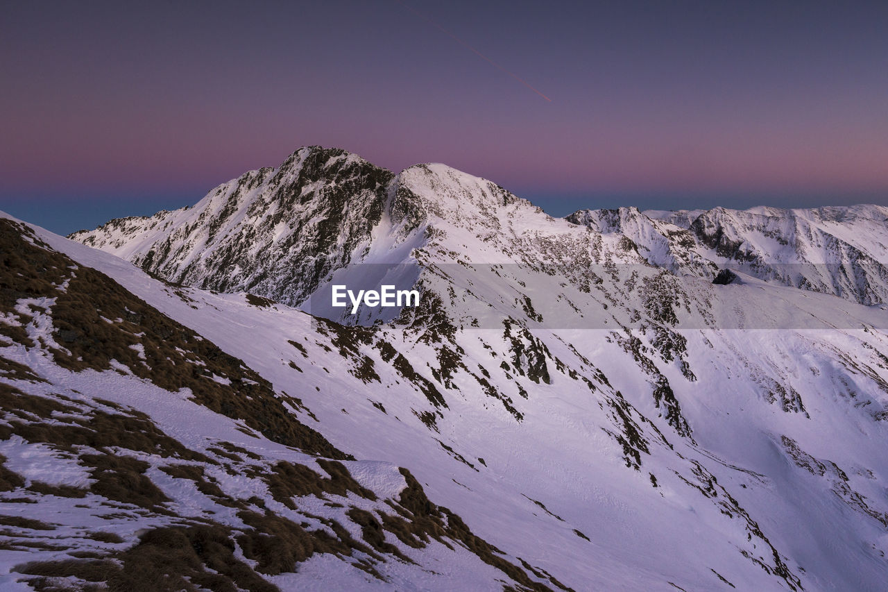 Scenic view of snow covered mountains against sky