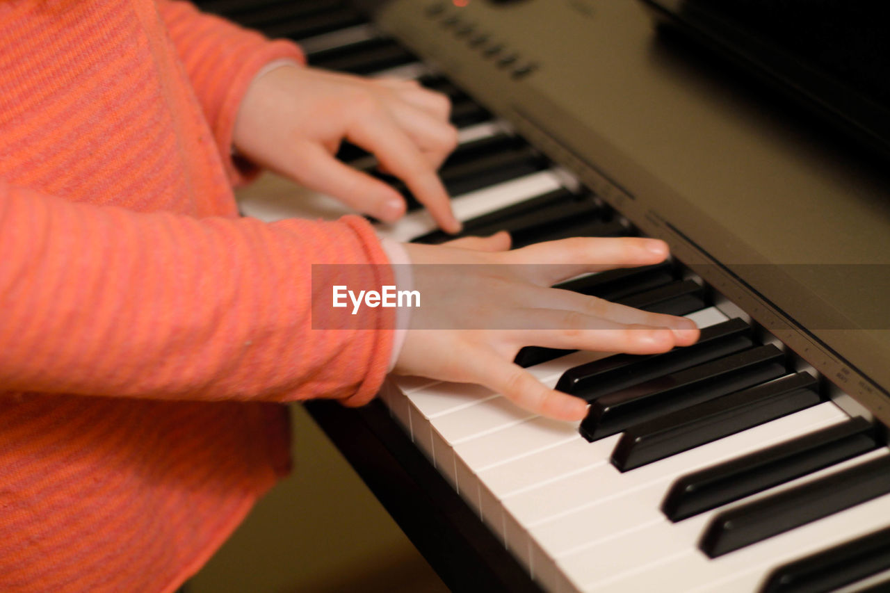 Cropped hands of boy playing piano