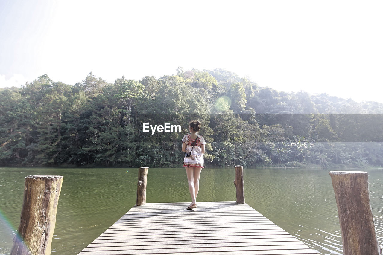 Full length of girl standing on pier over lake