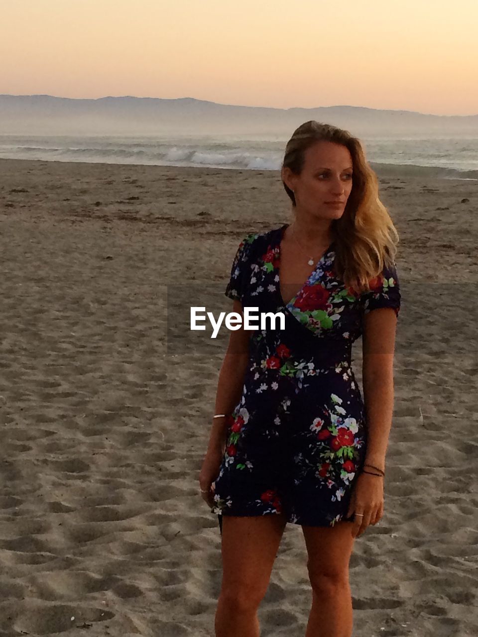 WOMAN STANDING ON BEACH