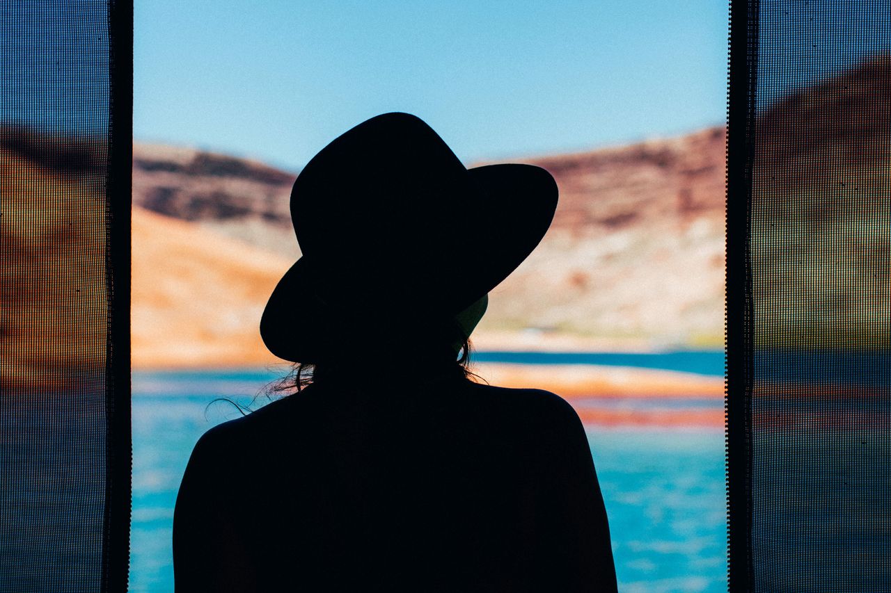 Rear view of silhouette woman looking at swimming pool against sky