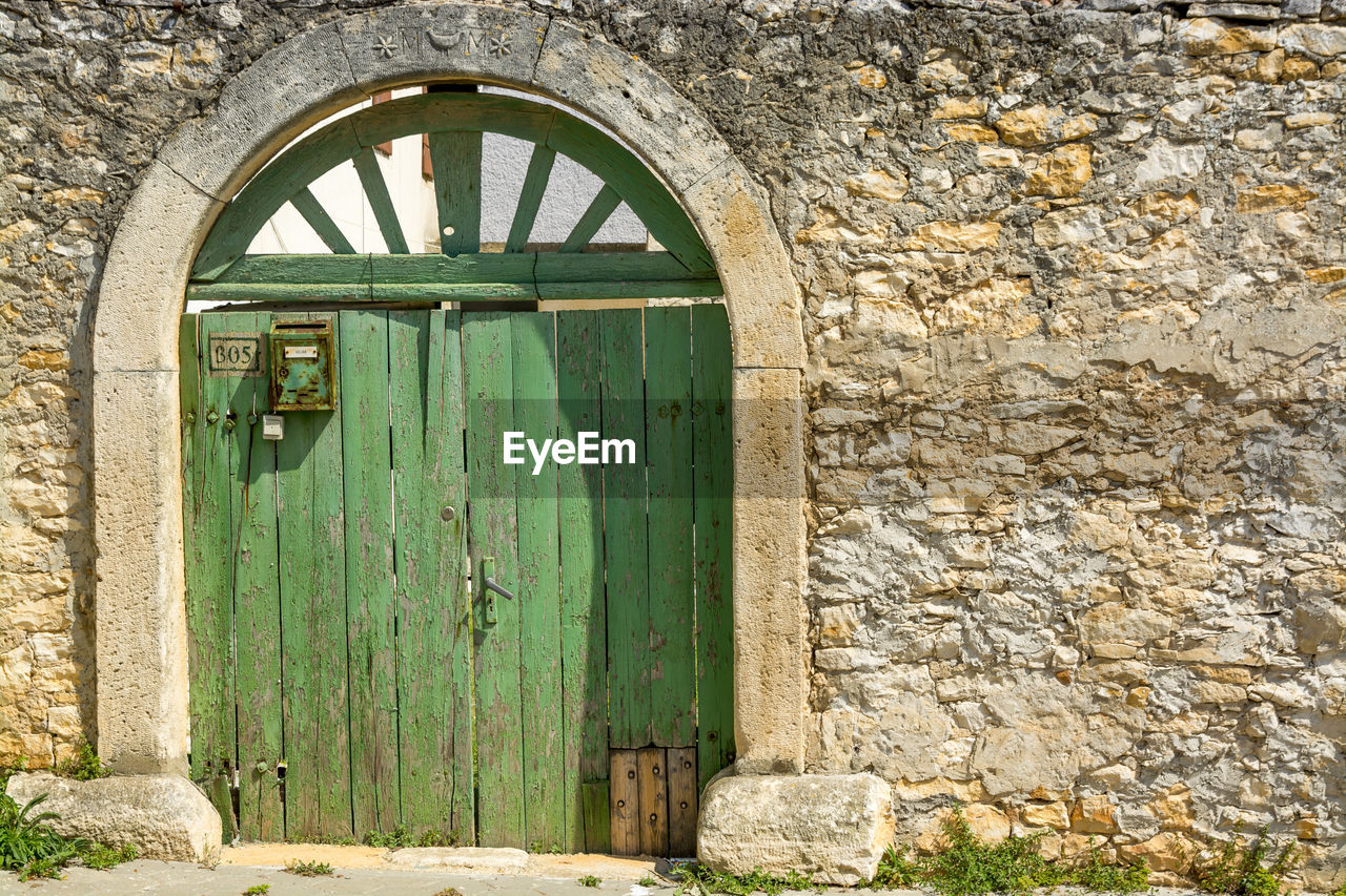 Closed, grren, wooden door of old building