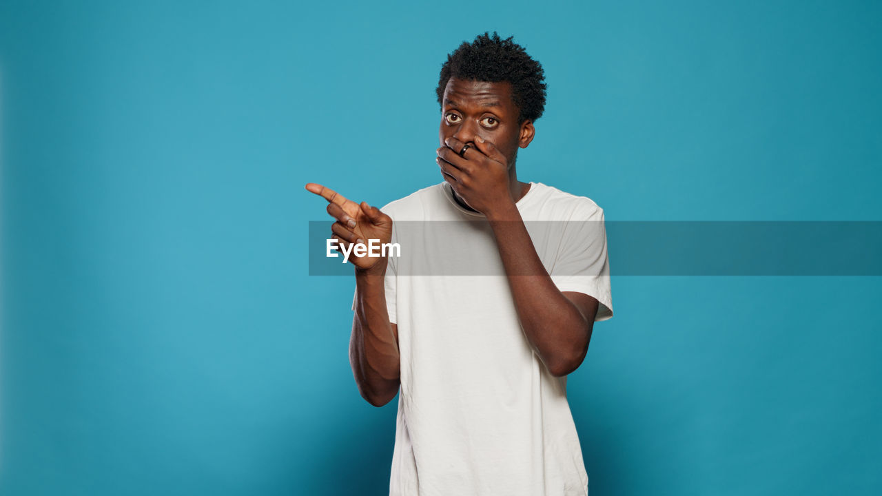 Man standing against blue background