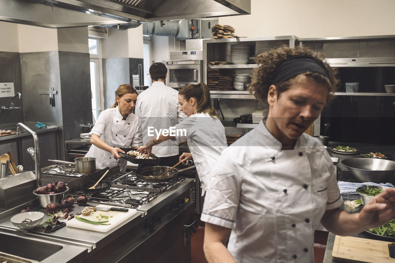 Chefs preparing food in kitchen at restaurant