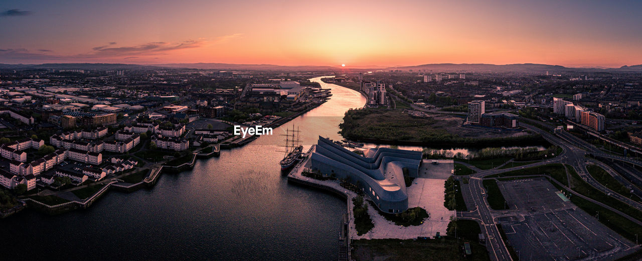 HIGH ANGLE VIEW OF RIVER AMIDST BUILDINGS IN CITY