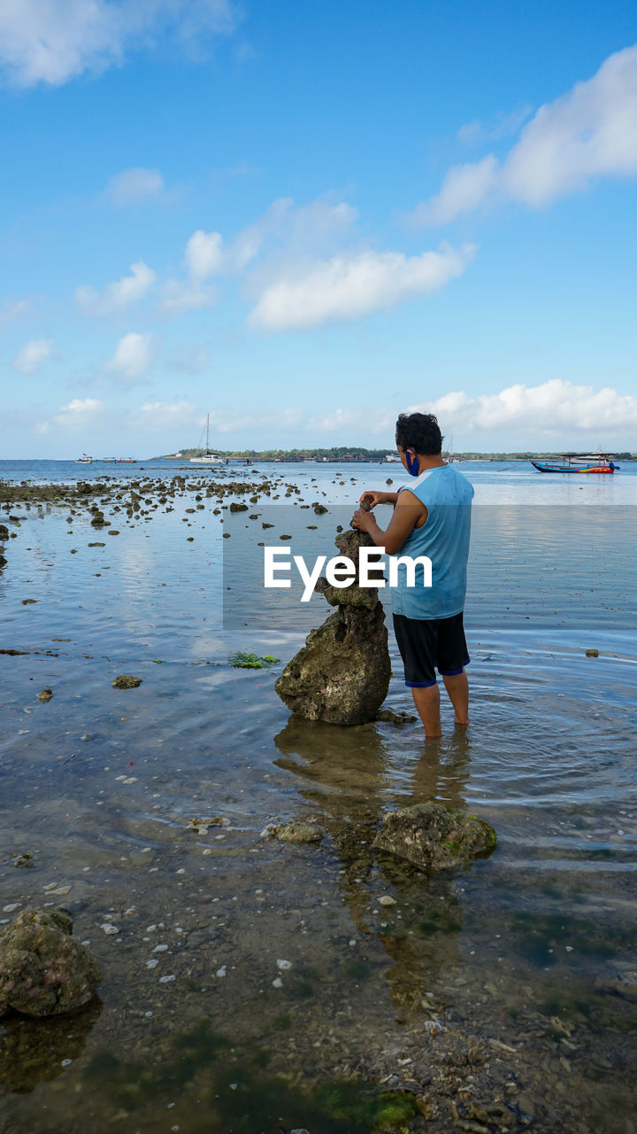 FULL LENGTH OF MAN STANDING ON SHORE