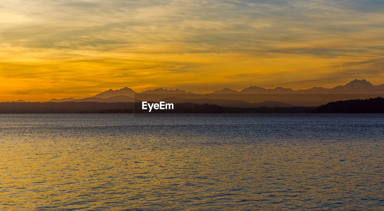 Olympic mountain range across the puget sound at sunset.