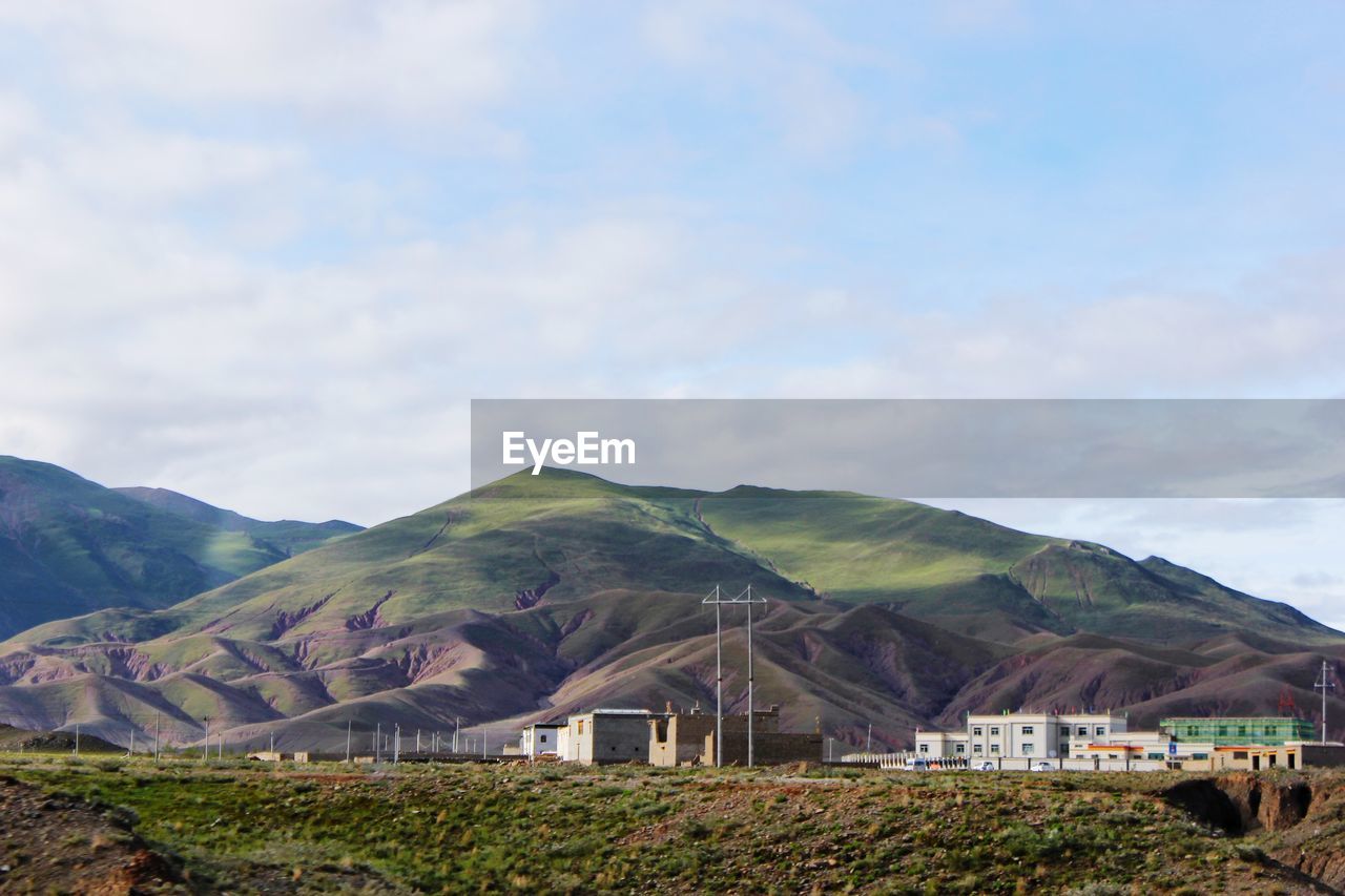 Houses by mountains against sky