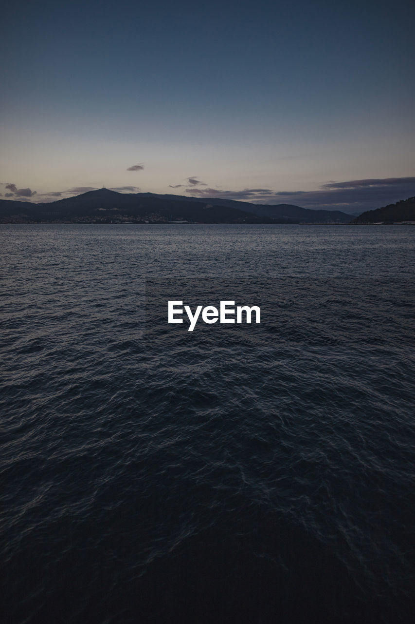 SCENIC VIEW OF SEA AGAINST SKY AT DUSK