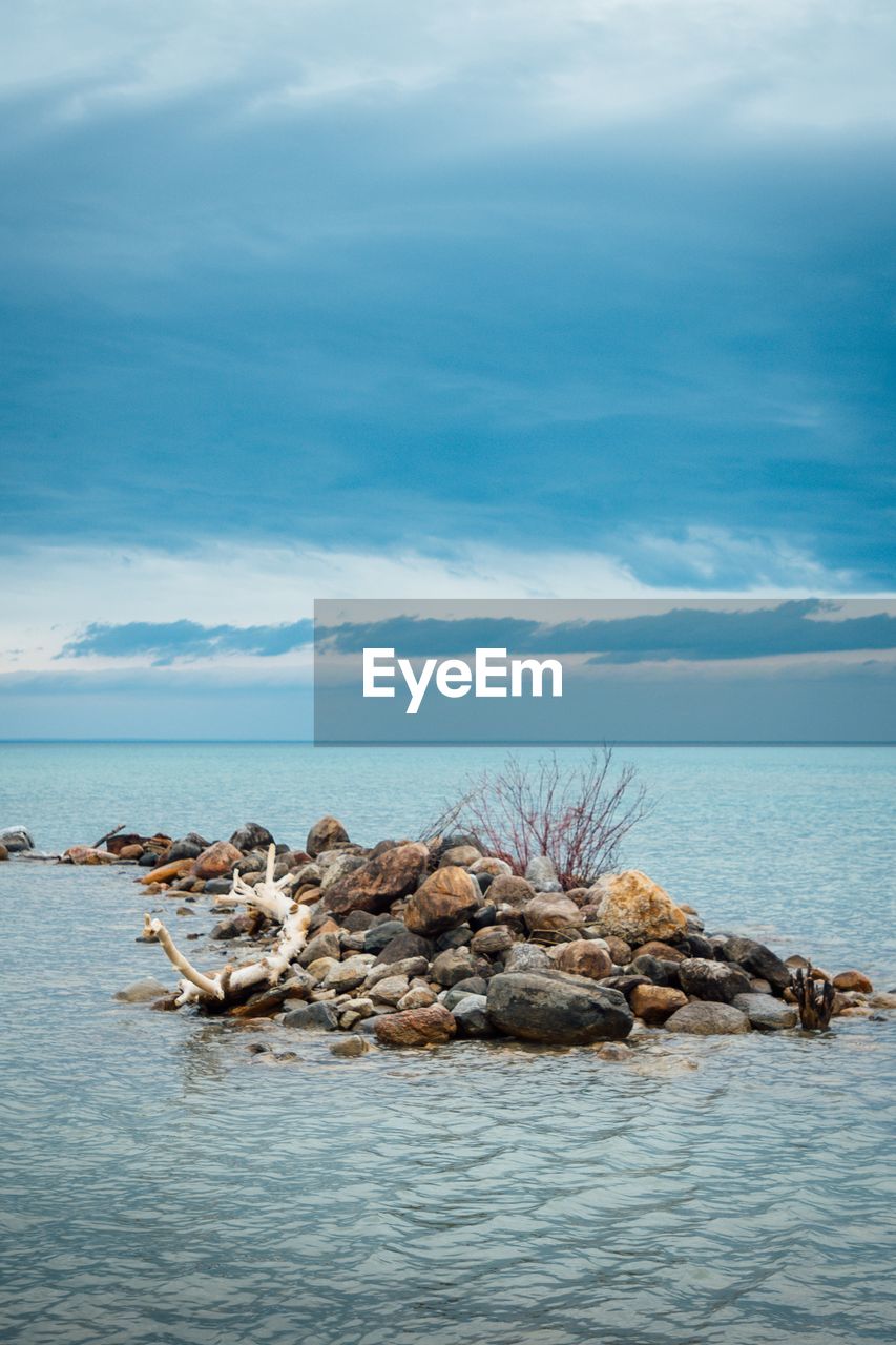 Rocks in sea against sky