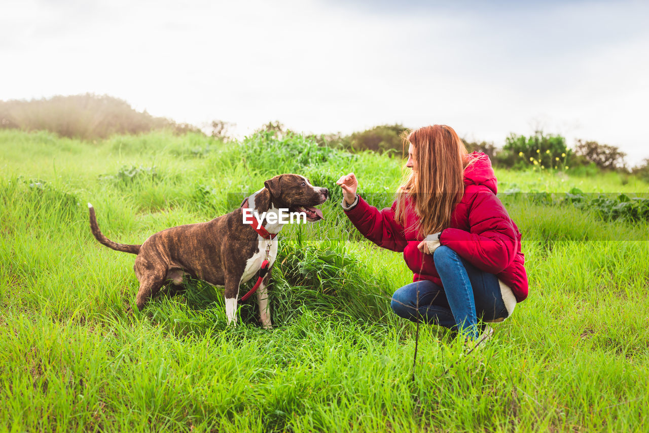 Woman with dog on field