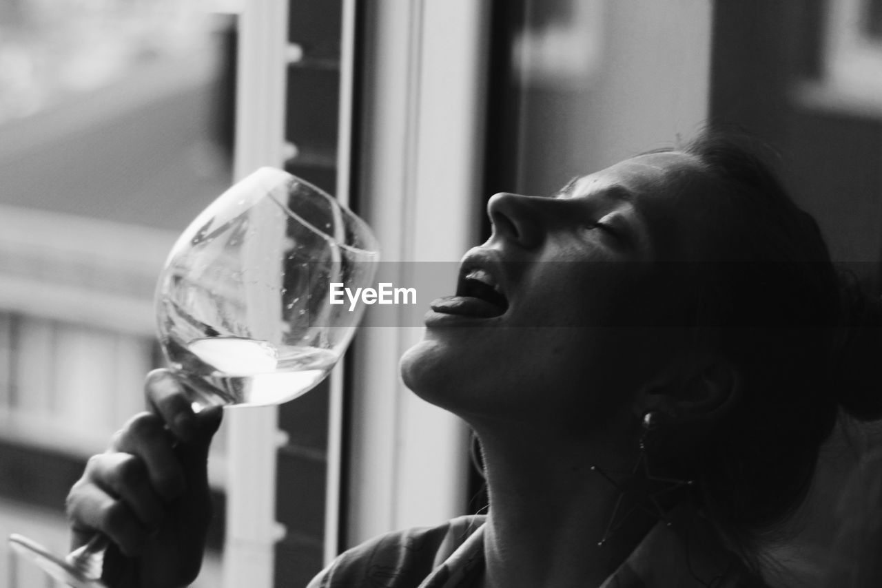 Close-up of woman drinking wine from glass