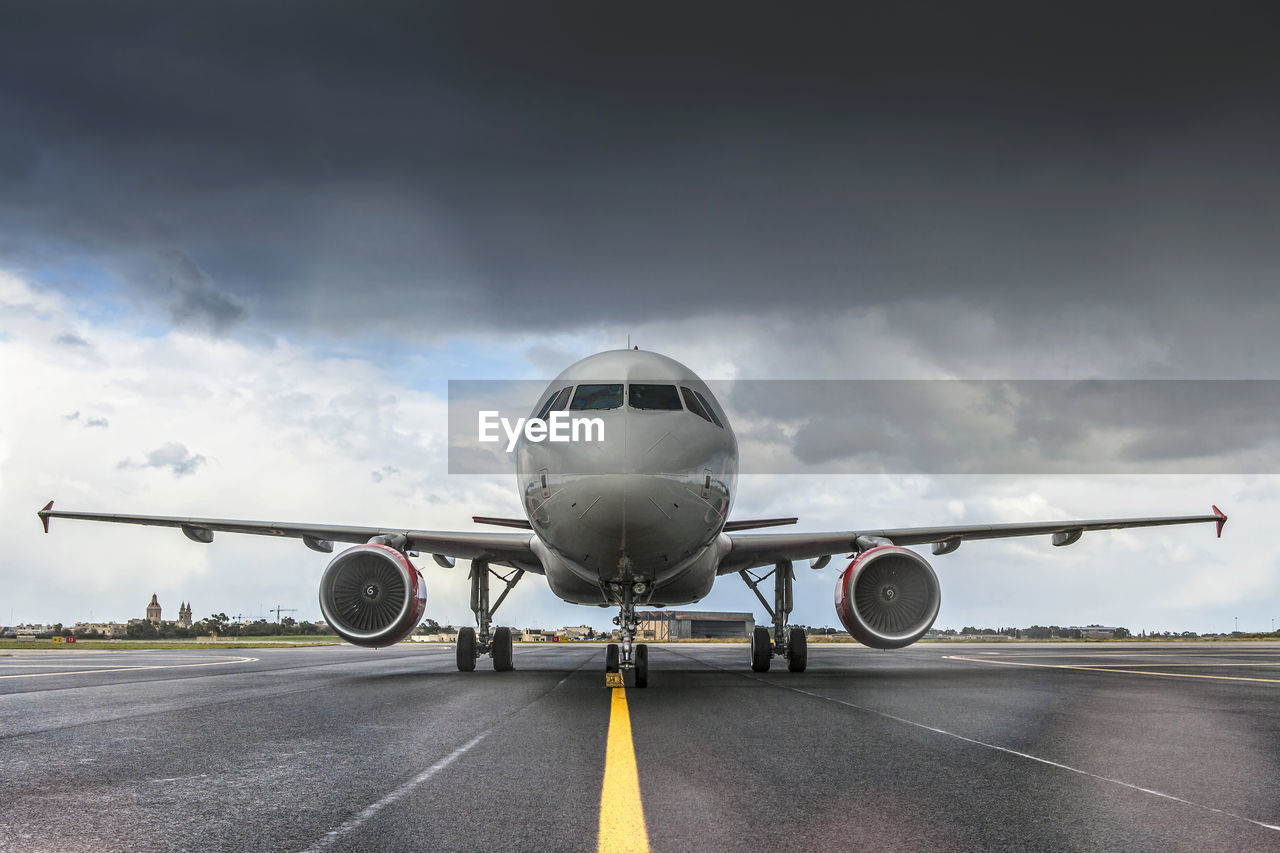 Airplane on runway against sky