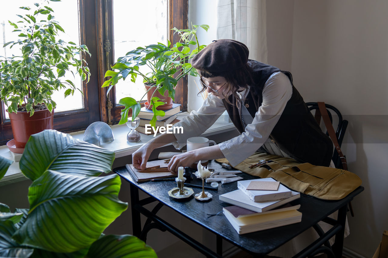 young woman using mobile phone while sitting at table