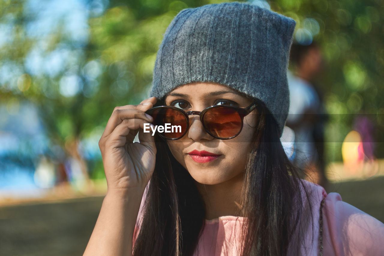 Portrait of young woman wearing sunglasses at park