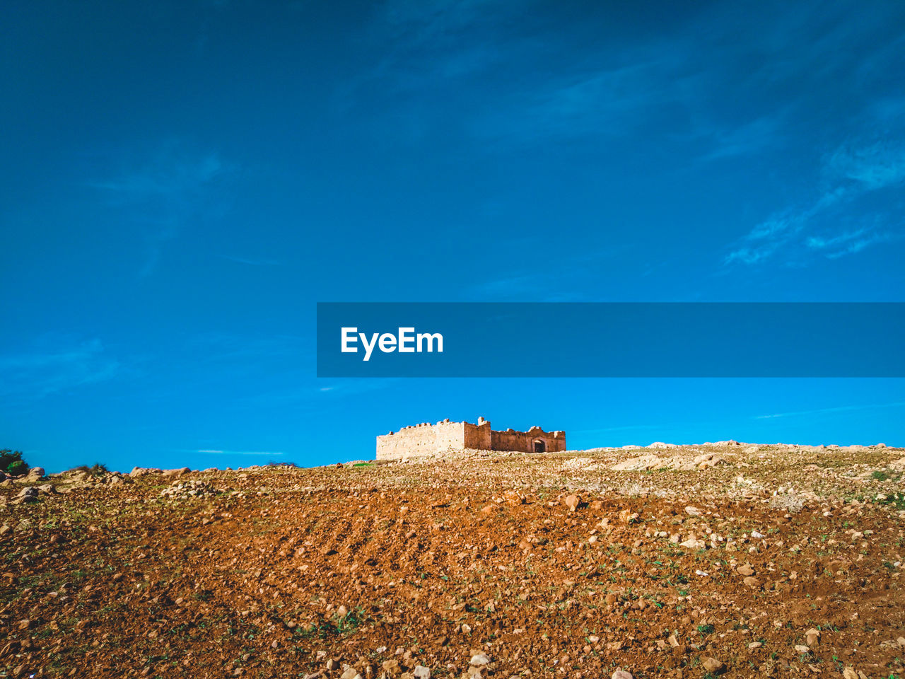 BUILDINGS ON FIELD AGAINST SKY