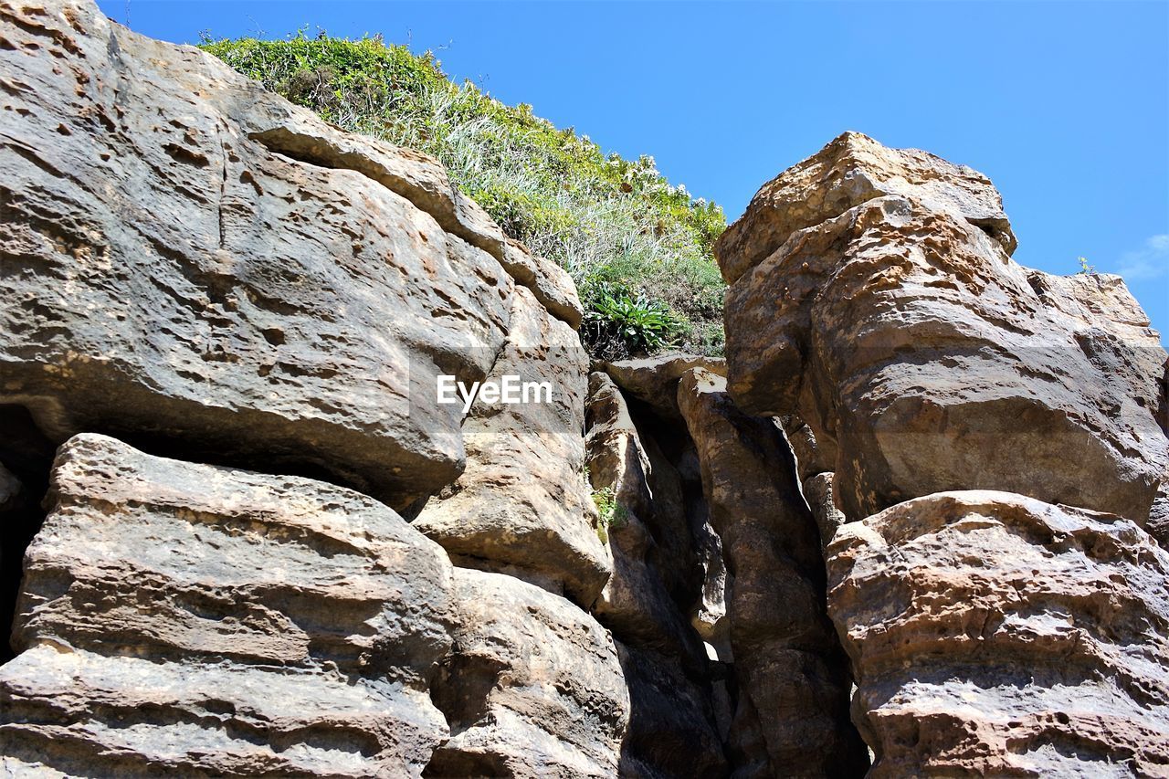 LOW ANGLE VIEW OF ROCK FORMATION ON MOUNTAIN AGAINST SKY