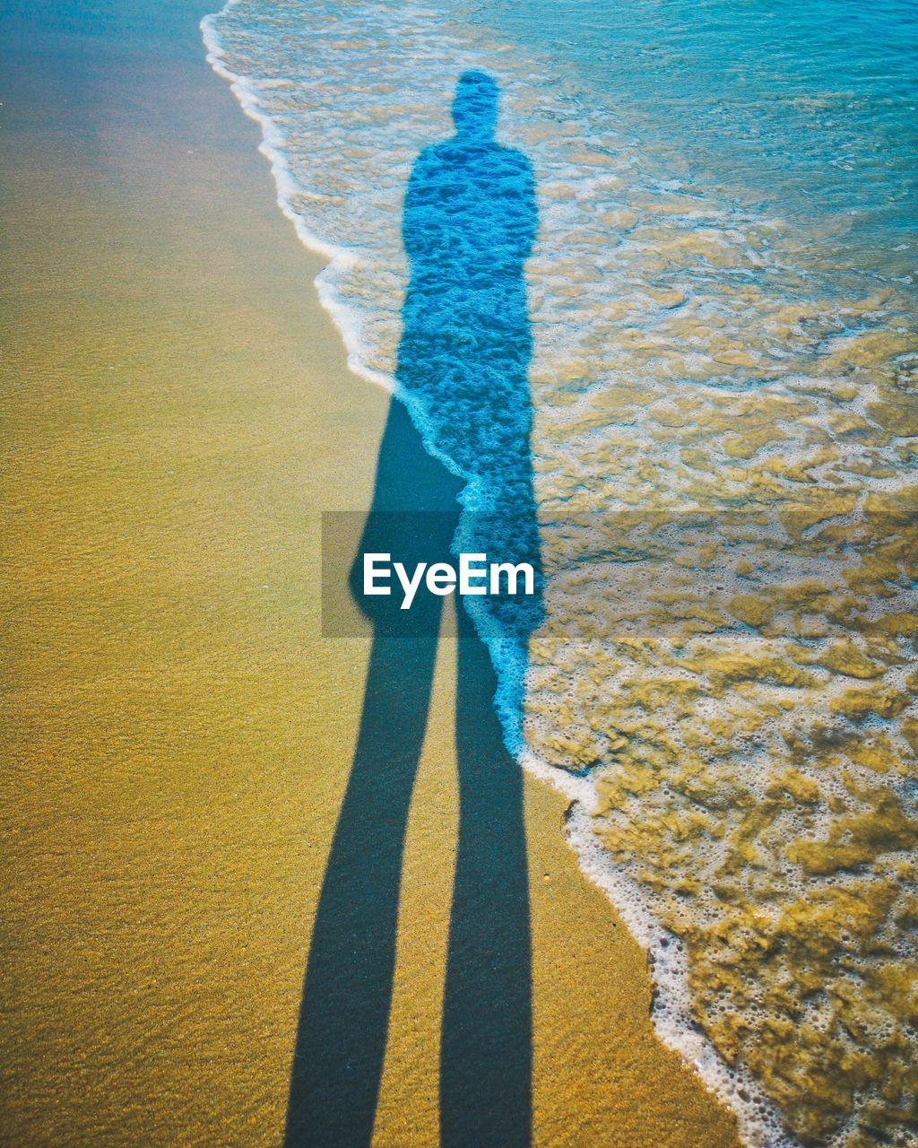 High angle view of man shadow on beach