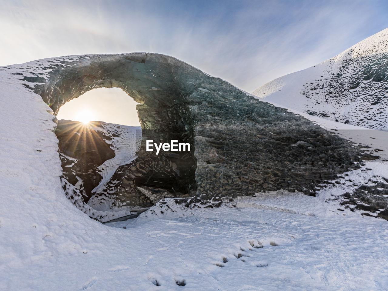 Natural arc of ice formation close to an ice cave, in iceland. at sunrise.